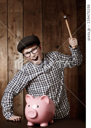 Hammer, portrait and boy child with piggy bank, savings or investment, growth or success at home. Cash, face and excited kid with smash tool for budget, change or container for fashion, sale or deal 139470286