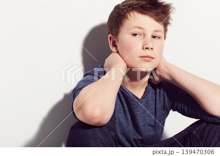Serious, teenager and boy thinking in studio sitting in white background with anxiety. Student, worry and kid with mental health, stress from school or pose in trendy outfit with clothes on backdrop Serious, teenager and boy thinking in studio sitting in white background with anxiety. Student, worry and kid with mental health, stress from school or pose in trendy outfit with clothes on backdrop 139470306