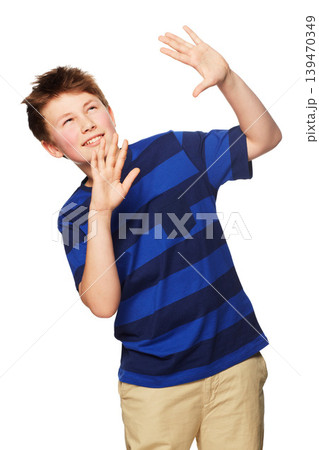Shock, hands raised and child with hiding, shield and protection looking up in a studio. Young boy, fashion and modern clothing with youth and scared from mockup with white background with kid 139470349