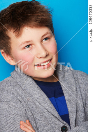 Fashion, thinking and boy child in studio with arms crossed confidence, smile or positive attitude on blue background. Style, face and proud fashionable kid model with cool, outfit or clothing choice Fashion, thinking and boy child in studio with arms crossed confidence, smile or positive attitude on blue background. Style, face and proud fashionable kid model with cool, outfit or clothing choice 139470358