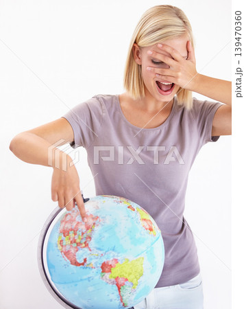 Wow, guess or pointing and a woman with a globe in studio on a white background for destination choice. World, planet and hand gesture to a location on earth for overseas travel decision or selection Wow, guess or pointing and a woman with a globe in studio on a white background for destination choice. World, planet and hand gesture to a location on earth for overseas travel decision or selection 139470360