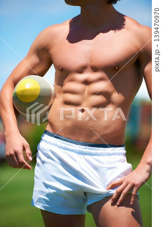 Topless, man and rugby player holding a ball closeup for training or sports practice on a field. Body, male athlete person and playing active competitive game for health and strength outdoors 139470970