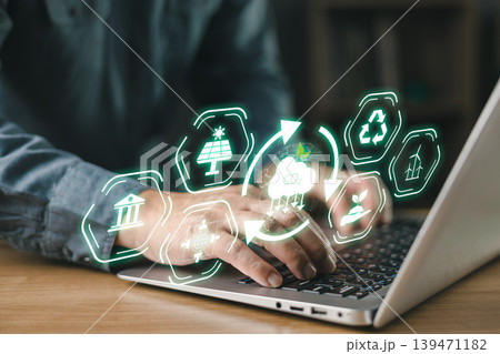 Person typing on laptop with floating eco icons, symbolizing sustainability, renewable energy, carbon reduction, green technology, and environmental responsibility in digital innovation.climate change 139471182