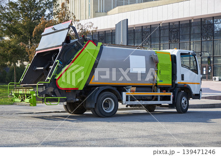 New garbage truck parked street. Modern waste management vehicle for trash collection and city cleaning service. Industrial equipment for municipal sanitation and environmental maintenance. 139471246