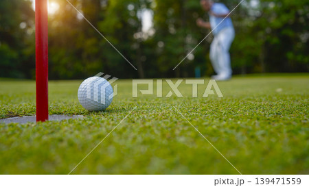 Golfers are putting golf in the evening golf course golf backglound. Golfers are putting golf in the evening golf course golf backglound. 139471559