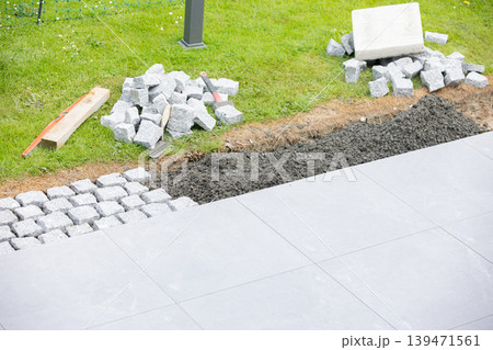 Cobblestone pavement installation tools and materials on construction site Cobblestone pavement installation tools and materials on construction site 139471561