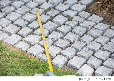 Measuring cobblestone pavement during installation Measuring cobblestone pavement during installation 139471566