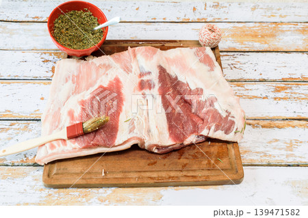 Preparation of a porchetta with a piece of fresh pork belly open in the thickness Preparation of a porchetta with a piece of fresh pork belly open in the thickness 139471582