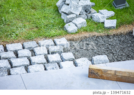 Cobblestone pavement installation with tools and groundwork preparation Cobblestone pavement installation with tools and groundwork preparation 139471632