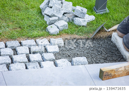 Cobblestone pavement installation with tools and groundwork preparation 139471635
