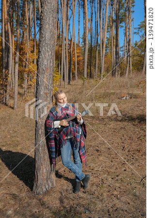 Beautiful blonde girl playing guitar ukulele and singing relaxing enjoying outdoors on sunny autumn day. Hippie woman in boho style training playing musical instrument. Fall leaves Beautiful blonde girl playing guitar ukulele and singing relaxing enjoying outdoors on sunny autumn day. Hippie woman in boho style training playing musical instrument. Fall leaves 139471820