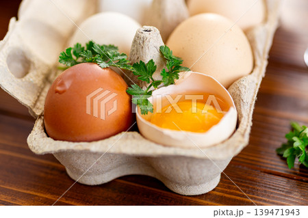 Natural eggs in box with whisk and herbs on kitchen table Natural eggs in box with whisk and herbs on kitchen table 139471943