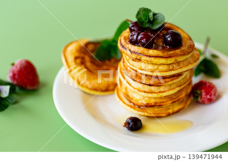 Sweet breakfast pancakes served with fresh berries and honey 139471944