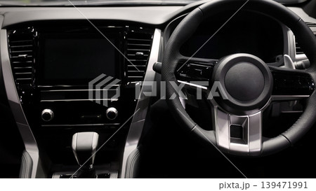 EV Car steering wheel. Modern car interior with luxury steering wheel dashboard and digital monitor controls. Steering wheel and automotive cabin. Car technology comfort and premium design in EV car. EV Car steering wheel. Modern car interior with luxury steering wheel dashboard and digital monitor controls. Steering wheel and automotive cabin. Car technology comfort and premium design in EV car. 139471991
