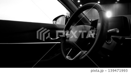 EV Car steering wheel. Modern car interior with luxury steering wheel dashboard and digital monitor controls. Steering wheel and automotive cabin. Car technology comfort and premium design in EV car. EV Car steering wheel. Modern car interior with luxury steering wheel dashboard and digital monitor controls. Steering wheel and automotive cabin. Car technology comfort and premium design in EV car. 139471993