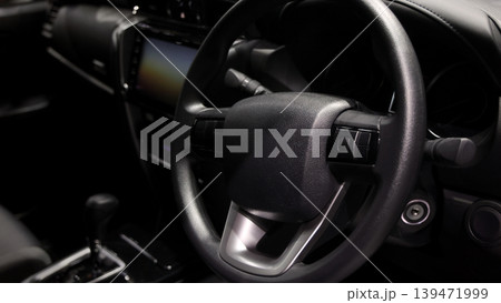 EV Car steering wheel. Modern car interior with luxury steering wheel dashboard and digital monitor controls. Steering wheel and automotive cabin. Car technology comfort and premium design in EV car. EV Car steering wheel. Modern car interior with luxury steering wheel dashboard and digital monitor controls. Steering wheel and automotive cabin. Car technology comfort and premium design in EV car. 139471999