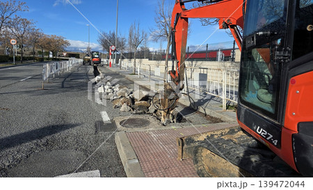 Road repair construction with excavator breaking up asphalt on a city street for infrastructure background and maintenance banner Road repair construction with excavator breaking up asphalt on a city street for infrastructure background and maintenance banner 139472044