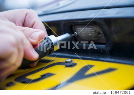 Unscrewing the screw from car light bulb, replacing the old light with a new one Unscrewing the screw from car light bulb, replacing the old light with a new one 139472061