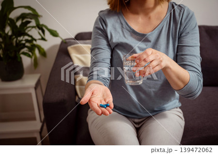 Woman holding blue pills in hand. Health care, dietary supplements, treatment of depression and diseases Woman holding blue pills in hand. Health care, dietary supplements, treatment of depression and diseases 139472062