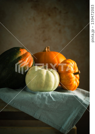 Orange, white and green pumpkins, rustic wooden moody background, autumn concept Orange, white and green pumpkins, rustic wooden moody background, autumn concept 139472083