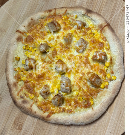 Fresh homemade pizza with grilled chicken corn and melted cheese on a wooden board. Cozy comfort food with crispy crust and golden baked texture Fresh homemade pizza with grilled chicken corn and melted cheese on a wooden board. Cozy comfort food with crispy crust and golden baked texture 139472447
