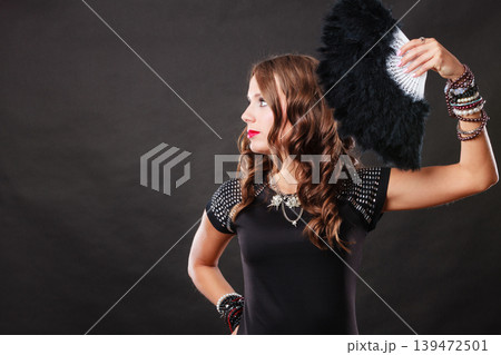 beautiful brunette woman with black fan in hand beautiful brunette woman with black fan in hand 139472501