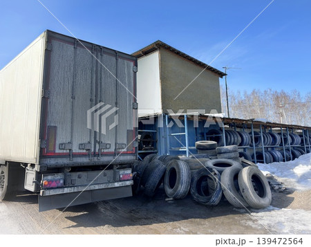 Tire fitting service for trucks, trucks, large cars. Warehouse of large wheels, tires on a street, blue sky 139472564