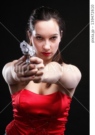 Sexy young woman - gun on black background 139472610