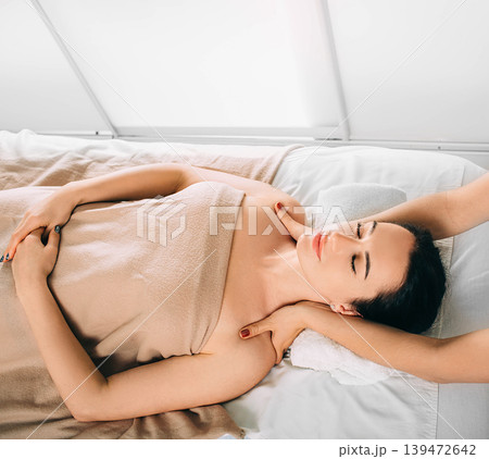 Brunette Woman relaxing during spa treatment . She receive relaxation massage while spa weekend 139472642
