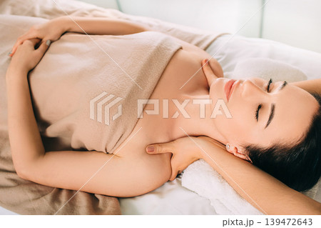 Brunette Woman relaxing during spa treatment . She receive relaxation massage while spa weekend 139472643