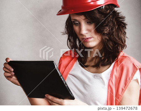 Sexy girl in safety helmet using tablet touchpad Sexy girl in safety helmet using tablet touchpad 139472678