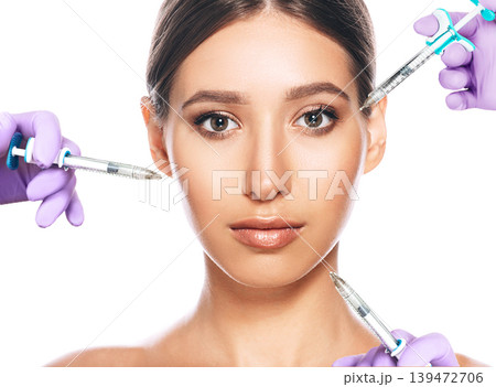 woman advertising concept of lifting skin using beauty injection iasolated on white. lot of syringes around a female face. non-surgical cosmetology 139472706