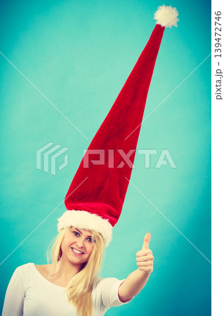 Woman wearing windblown crazy santa hat Woman wearing windblown crazy santa hat 139472746