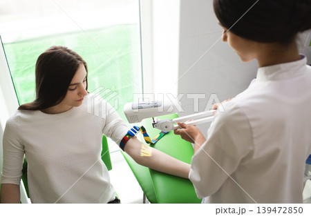 venous blood sampling for analysis. The nurse view the patient veins with the help of a special Vein scanner 139472850