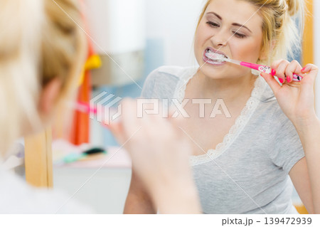 Woman brushing cleaning teeth in bathroom 139472939