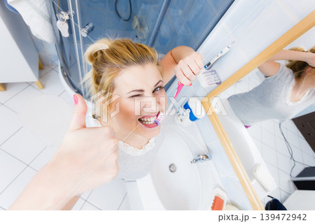 Woman brushing cleaning teeth in bathroom Woman brushing cleaning teeth in bathroom 139472942
