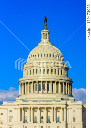 The dome of the Capitol building is visible with clear sky and few clouds on a sunny day in Washington D.C. 139473096