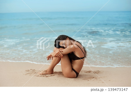 Beautiful woman in swimwear with copy space on the beach. Portrait of pretty girl with slim tanned sexy body in black bikini enjoying life. Summer lifestyle. Vacation 139473147