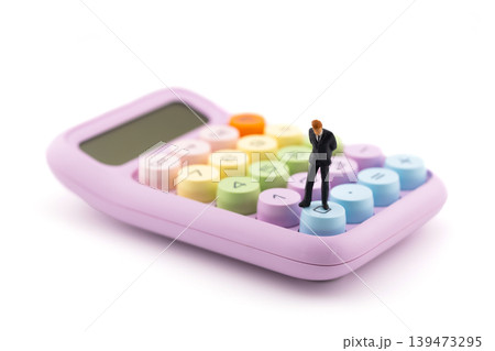Miniature businessman standing on a colorful calculator for financial and business concept Miniature businessman standing on a colorful calculator for financial and business concept 139473295