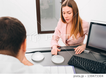 breast augmentation. Young woman chooses breast implant breast augmentation. Young woman chooses breast implant 139473304