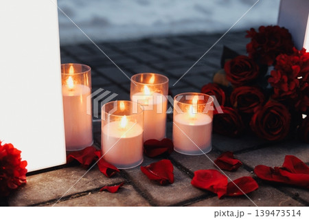Romantic Candlelit Memorial Scene Glowing Candles, Red Rose Bouquet Beside Glass Votives On Wooden Floor, Scattered Petals And Warm Wax Glows, Evening Vigil Mood, Intimate Solemn Tribute Romantic Candlelit Memorial Scene Glowing Candles, Red Rose Bouquet Beside Glass Votives On Wooden Floor, Scattered Petals And Warm Wax Glows, Evening Vigil Mood, Intimate Solemn Tribute 139473514