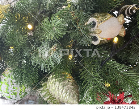 Christmas tree adorned with illuminated ornaments and pinecones for festive winter background Christmas tree adorned with illuminated ornaments and pinecones for festive winter background 139473848