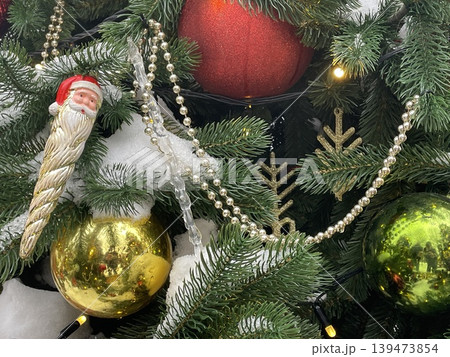 Christmas tree decorated with shiny ornaments, golden baubles, pine branches, and festive garland Christmas tree decorated with shiny ornaments, golden baubles, pine branches, and festive garland 139473854