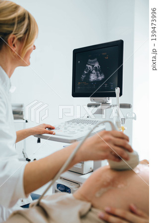 female doctor doing sonogram with pregnant woman at clinic. pregnant patient ultrasound exam female doctor doing sonogram with pregnant woman at clinic. pregnant patient ultrasound exam 139473996