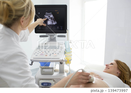 Pregnant woman having sonogram at clinic. pregnant patient ultrasound exam Pregnant woman having sonogram at clinic. pregnant patient ultrasound exam 139473997