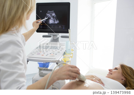 Pregnant woman having sonogram at clinic. pregnant patient ultrasound exam 139473998