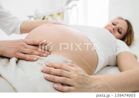 Pregnant woman at a checkup with her female doctor at clinic Pregnant woman at a checkup with her female doctor at clinic 139474003