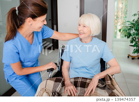 Psychological support, a nurse and an elderly woman in a wheelchair have communication. Caring for people with disabilities Psychological support, a nurse and an elderly woman in a wheelchair have communication. Caring for people with disabilities 139474357