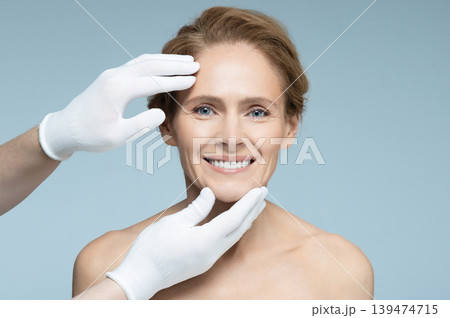 Plastic surgery, concept. Ideal shape of woman face for plastic surgery, reference female face on blue background Plastic surgery, concept. Ideal shape of woman face for plastic surgery, reference female face on blue background 139474715