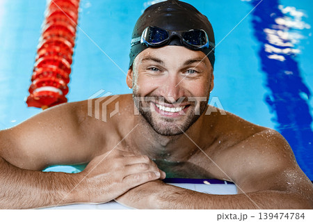 Portrait of smiling man, a swimmer on the rooftop pool. Swimmer in the swimming pool Portrait of smiling man, a swimmer on the rooftop pool. Swimmer in the swimming pool 139474784